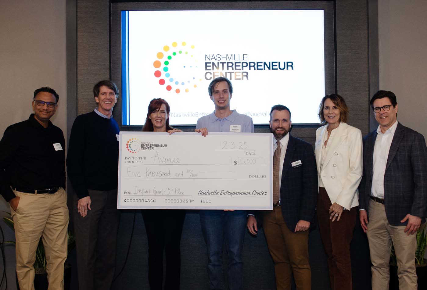 Third-place Impact Grant winners accepting $5,000 on stage