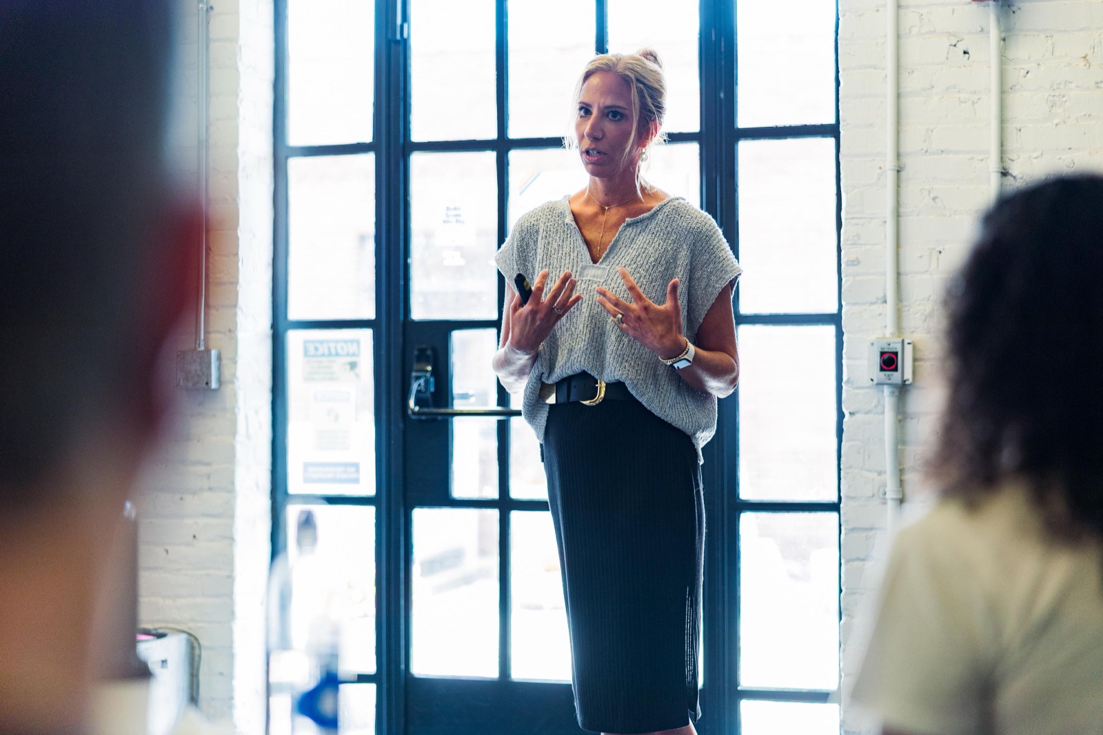 A founder gesturing while pitching, audience silhouetted in the foreground