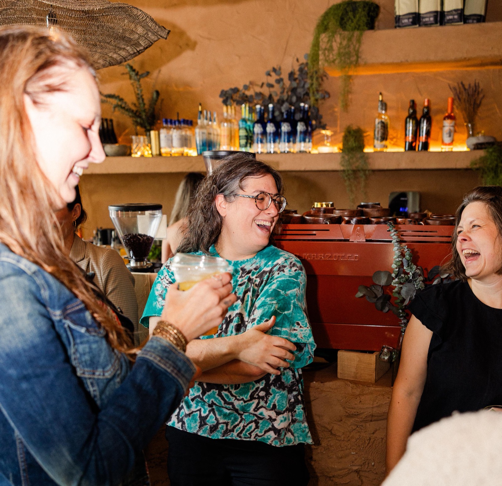 Three women founders laughing together at cafe babu