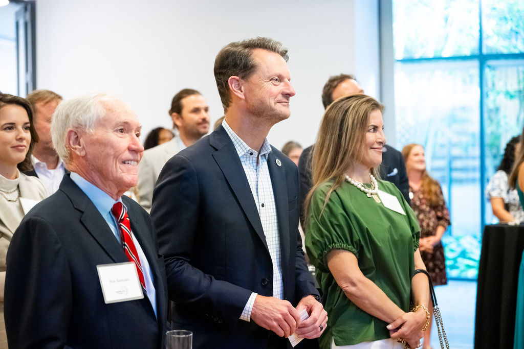 Three guests standing together listening during the McWhorter Circle Legacy Celebration