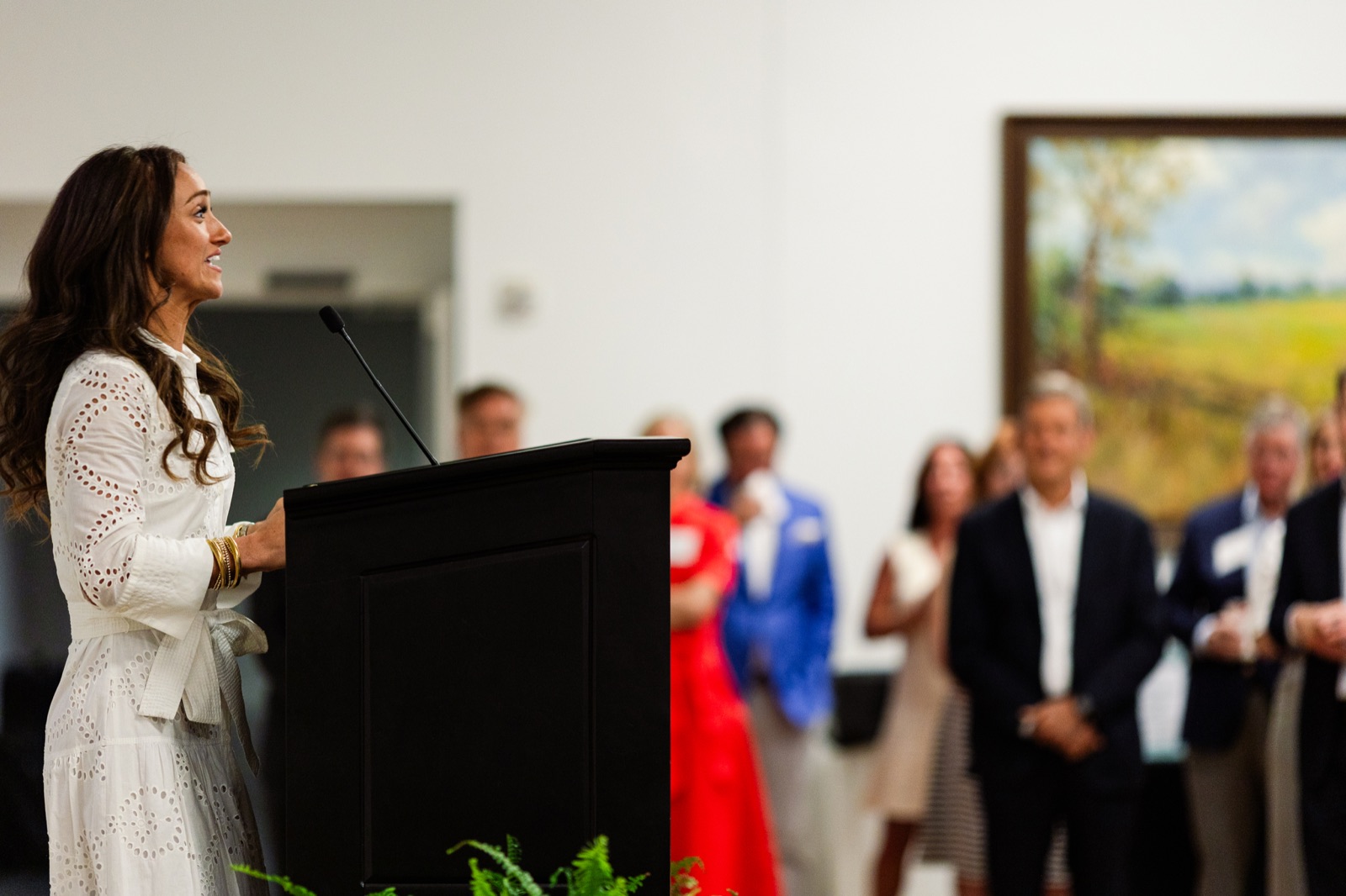 A speaker at a podium addressing a standing crowd