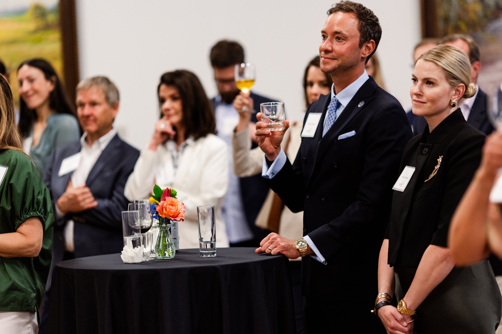 Guests raising glasses in a toast at a cocktail table