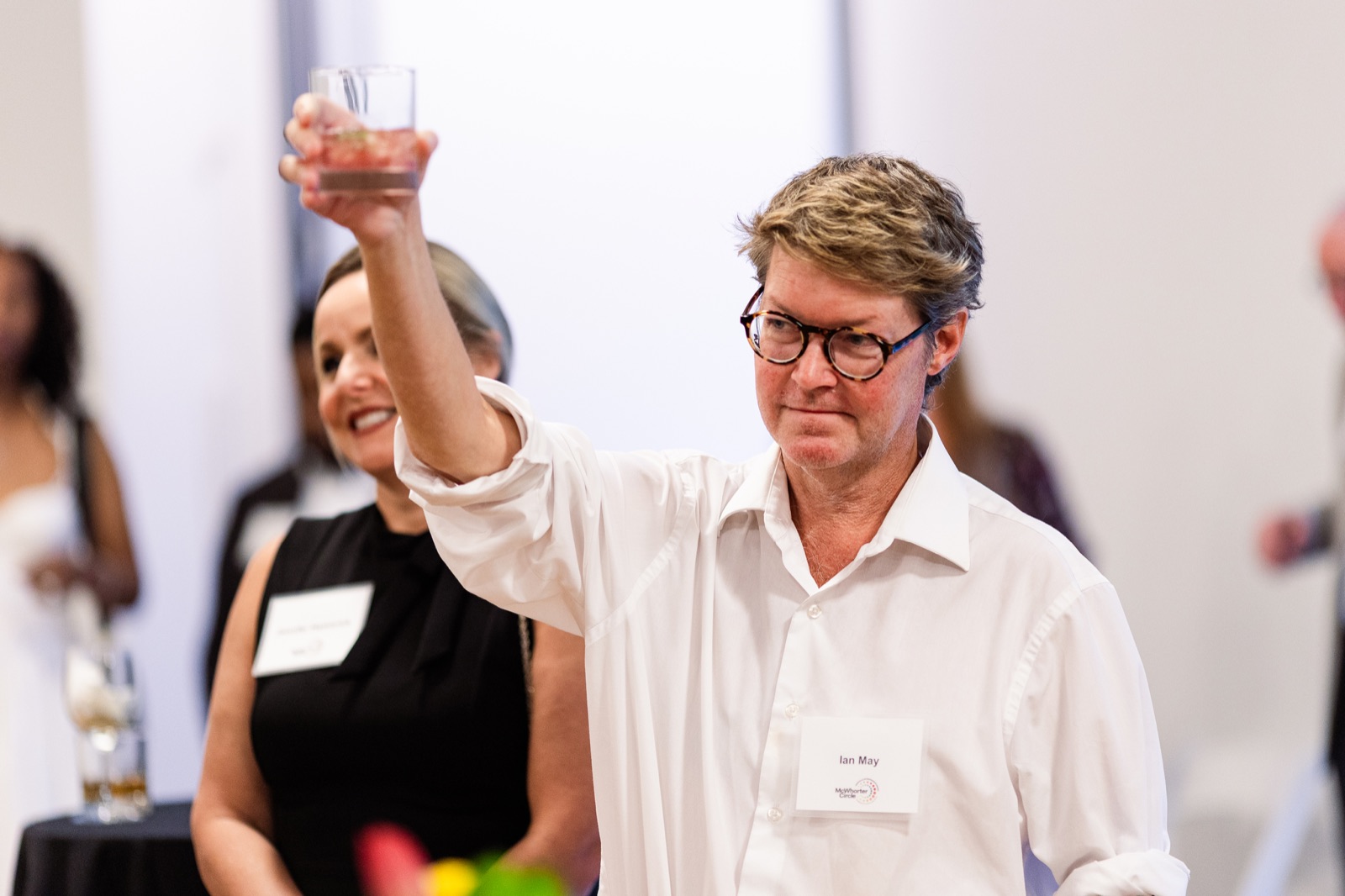 A guest raising a glass high above the crowd