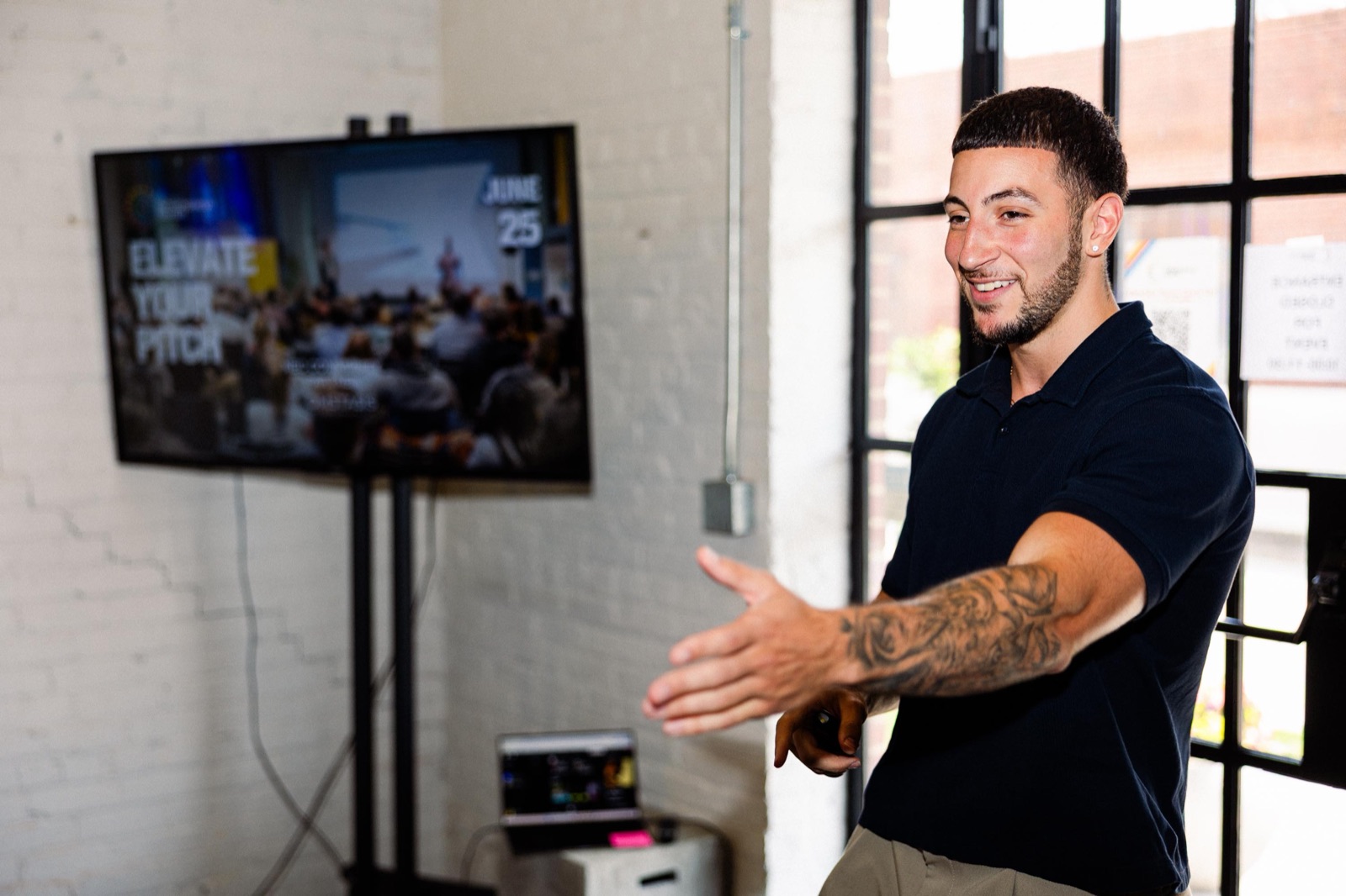 Trea McCoy, EC Community Manager, gesturing mid-conversation at an Elevate Your Pitch event