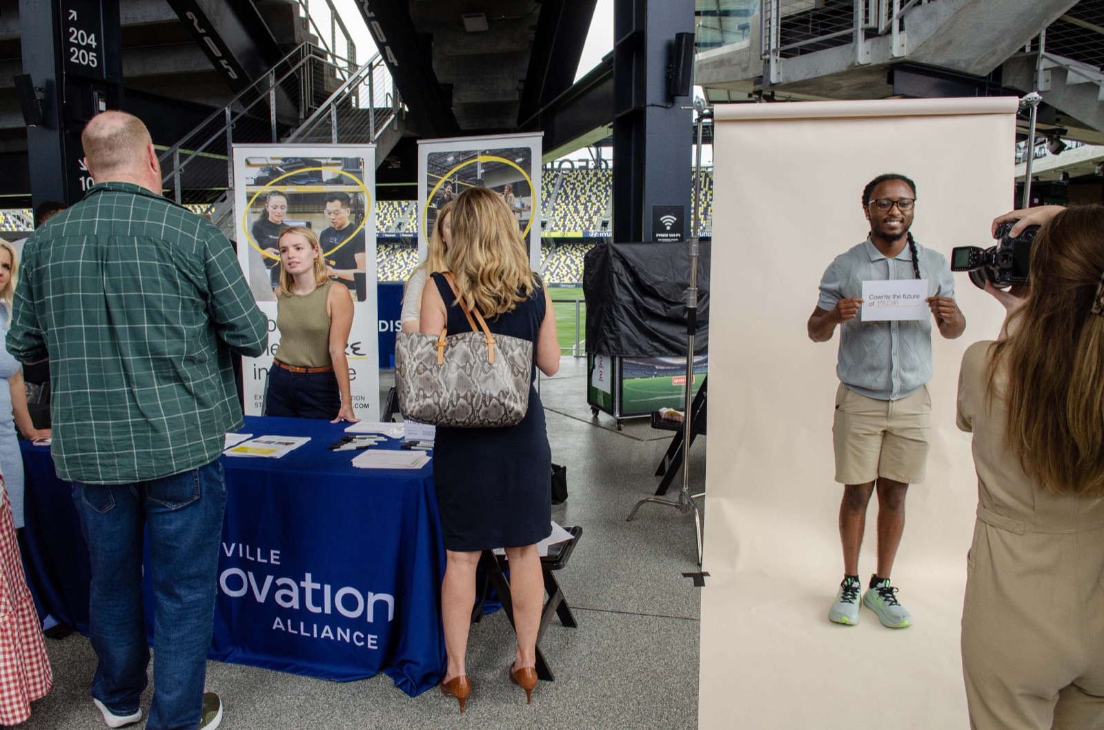 A row of founder expo booths with attendees stopping to talk