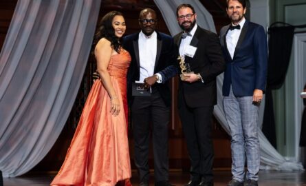 Brian Bauer on stage at the Schermerhorn Symphony Center holding BEM's 2021 NEXT Award